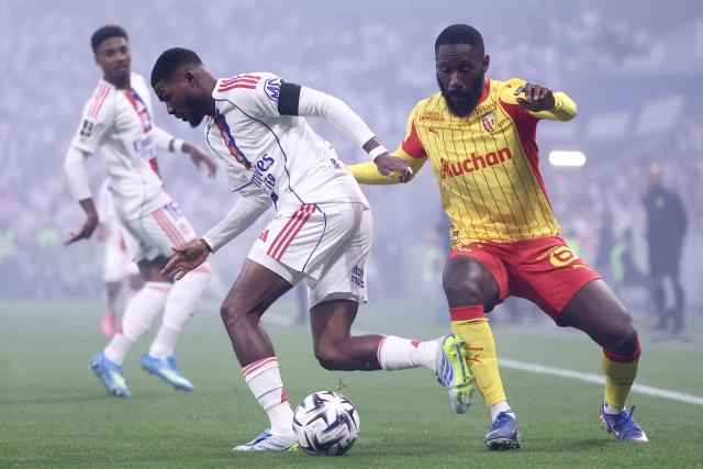 Lyon's English midfielder #98 Ainsley Maitland-Niles (L) fights for the ball with Lens' DR Congo defender Arthur Masuaku (R) during the French L1 football match between Olympique Lyonnais (OL) and RC Lens at the Groupama Stadium in Decines-Charpieu, central-eastern France, on May 17, 2026. (Photo by Alex MARTIN / AFP)