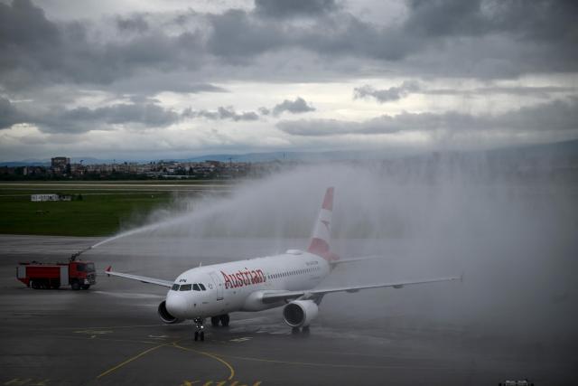 An Austrian airline airplane carrying  Bulgarian singer Dara aboard arrives under a water arch formed by fire trucks at Vassil Levski airport in Sofia on May 17, 2026. (Photo by Nikolay DOYCHINOV / AFP)