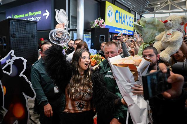 Bulgarian singer Dara lifts her trophy as she is welcomed by supporters upon her arrival in Sofia, one day after winning the Eurovision Song Contest with her song "Bangaranga," on May 17, 2026. (Photo by Nikolay DOYCHINOV / AFP)