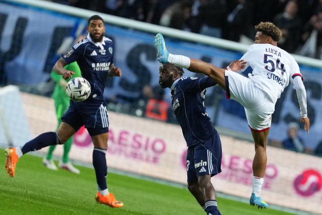 Paris FC's French midfielder #93 Jonathan Ikone (C) and Paris Saint-Germain's French defender #54 Dimitri Lucea (R) fight for the ball during the French L1 football match between Paris FC and Paris Saint-Germain (PSG) at the Stade Jean-Bouin in Paris on May 17, 2026. (Photo by Dimitar DILKOFF / AFP)