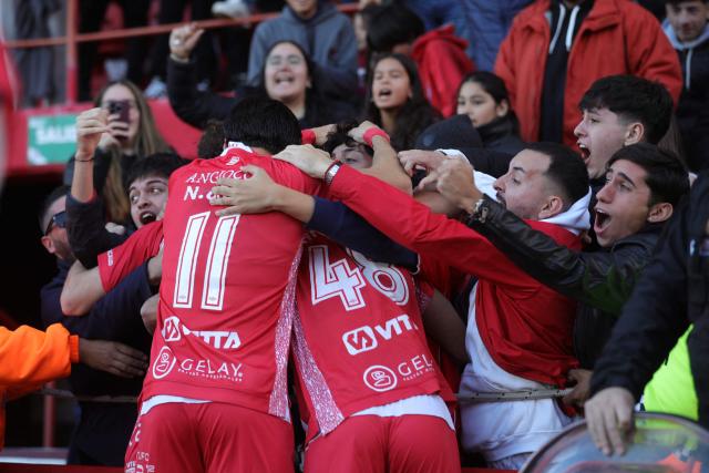 Argentinos Juniors' forward #48 Facundo Jainikoski (C) celebrates with teammate midfielder #11 Nicolas Oroz and fans after scoring his team's first goal during the Argentine Professional Football League Apertura tournament semifinal match between Argentinos Juniors and Belgrano at the Diego Armando Maradona stadium in Buenos Aires on May 17, 2026. (Photo by Alejandro PAGNI / AFP)