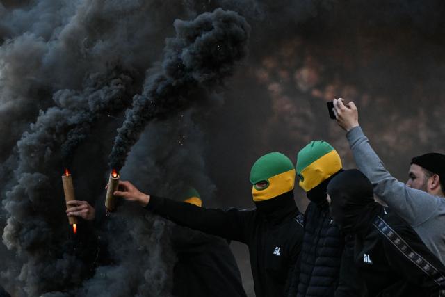 TOPSHOT - Nantes' supporters holding smoke flares attempt to invade the pitch during the French L1 football match between FC Nantes and Toulouse FC at the Stade de la Beaujoire–Louis Fonteneau in Nantes, western France, on May 17, 2026. (Photo by Sebastien Salom-Gomis / AFP)