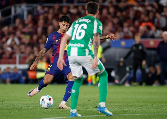 Barcelona's Portuguese defender #02 Joao Cancelo scores his team's third goal during the Spanish league football match between FC Barcelona and Real Betis at the Camp Nou Stadium in Barcelona on May 17, 2026. (Photo by JAIME REINA / AFP)