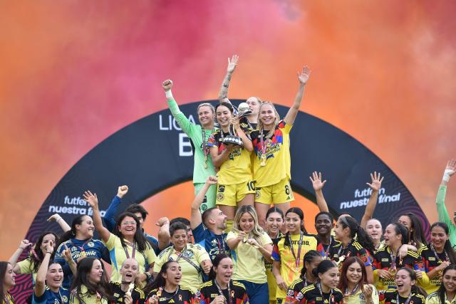 America's forward #10 Scarlett Camberos (C) lifts the trophy with her teammates after winning the Liga MX Femenil women's Clausura final second-leg football match between America and Monterrey at the Ciudad de los Deportes stadium in Mexico City on May 17, 2026. (Photo by Rodrigo Oropeza / AFP)