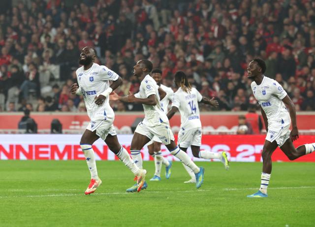 Auxerre's Malian forward #10 Lassine Sinayoko(L) is congratulated by teamates after scoring  during the French L1 football match between Lille LOSC and AJ Auxerre at the Stade Pierre-Mauroy in Villeneuve-d'Ascq, northern France, on May 17, 2026. (Photo by Francois LO PRESTI / AFP)