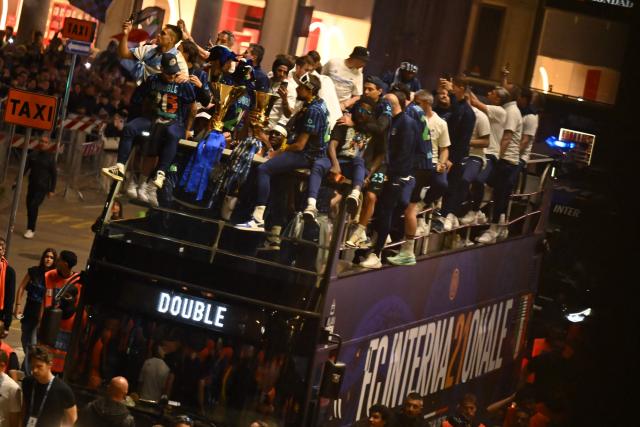 Inter Milan's players and staff arrive at Piazza Duomo on an open bus at the end of a parade in the city to celebrate their 21st scudetto (Italian Championship victory), in Milan on May 17, 2026. (Photo by PIERO CRUCIATTI / AFP)
