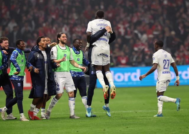 Auxerre's Malian forward #10 Lassine Sinayoko(C) is congratulated by teamates after scoring  during the French L1 football match between Lille LOSC and AJ Auxerre at the Stade Pierre-Mauroy in Villeneuve-d'Ascq, northern France, on May 17, 2026. (Photo by Francois LO PRESTI / AFP)