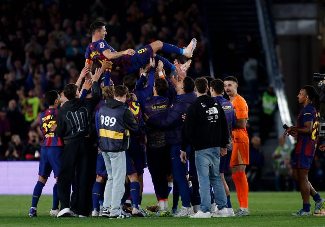 Barcelona's Polish forward #09 Robert Lewandowski is tossed in the air by teammates at the end of the Spanish league football match between FC Barcelona and Real Betis at the Camp Nou Stadium in Barcelona on May 17, 2026. Barcelona striker Robert Lewandowski said yesterday he is leaving the club this summer at the end of his contract. The veteran Polish forward, 37, scored 119 goals for Barcelona in 191 games across all competitions since joining from Bayern Munich in 2022. (Photo by JAIME REINA / AFP)