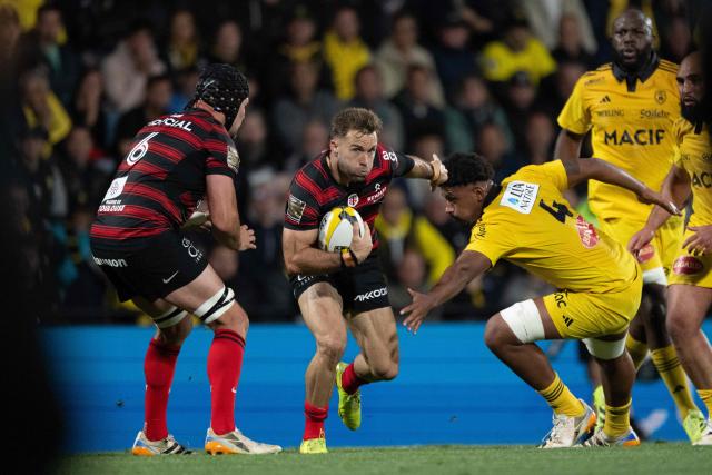 Toulouse's Paul Graou (C) runs with the ball during the French Top14 rugby union match between Stade Rochelais (La Rochelle) and Stade Toulousain (Toulouse) at the Marcel-Deflandre Stadium in La Rochelle, western France,on May 17, 2026. (Photo by XAVIER LEOTY / AFP)