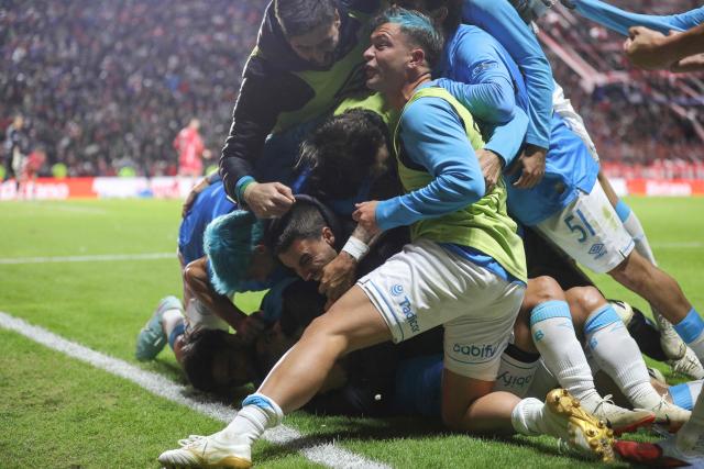 Belgrano's forward #22 Nicolas Fernandez celebrates with teammates after scoring a late equalising goal to force extra-time during the Argentine Professional Football League Apertura tournament semifinal match between Argentinos Juniors and Belgrano at the Diego Armando Maradona stadium in Buenos Aires on May 17, 2026. (Photo by Alejandro PAGNI / AFP)