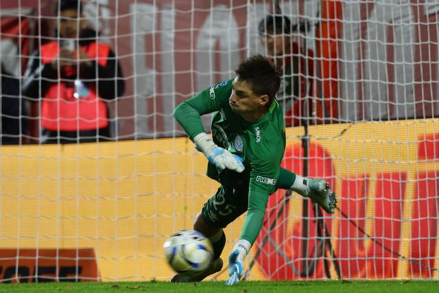Belgrano's Uruguayan goalkeeper #25 Thiago Cardozo stops a penalty to win the penalty shoot-out of the Argentine Professional Football League Apertura tournament semifinal match between Argentinos Juniors and Belgrano at the Diego Armando Maradona stadium in Buenos Aires on May 17, 2026. (Photo by Alejandro PAGNI / AFP)