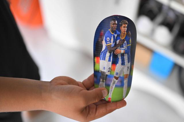 Julian Hidalgo, a fan of Ecuadorian football player Moises Caicedo, shows a shin pad featuring images of Moises and Ecuadorian football player Jeremy Sarmiento at his home in Santo Domingo, Ecuador, on May 8, 2026. Amid the tightly packed houses of a working-class Ecuadorian neighborhood, national team football player Moises Caicedo lifted his first trophies. They were made of gold-colored plastic, lent by a neighbor to add excitement to the impromptu game played by a group of children from which one of the world's most highly regarded midfielders emerged. Caicedo, now a Chelsea player, will compete in his second World Cup with Ecuador at just 24 years old. (Photo by Rodrigo BUENDIA / AFP)