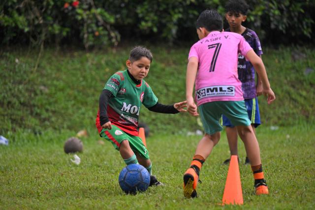 Julian Hidalgo, a fan of Ecuadorian football player Moises Caicedo, controls the ball during a training session at the IG 10 Moises Caicedo football school in the Mujer Trabajadora neighborhood in Santo Domingo, Ecuador, on May 8, 2026. Amid the tightly packed houses of a working-class Ecuadorian neighborhood, national team football player Moises Caicedo lifted his first trophies. They were made of gold-colored plastic, lent by a neighbor to add excitement to the impromptu game played by a group of children from which one of the world's most highly regarded midfielders emerged. Caicedo, now a Chelsea player, will compete in his second World Cup with Ecuador at just 24 years old. (Photo by Rodrigo BUENDIA / AFP)