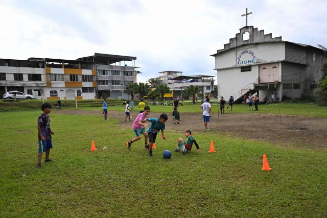 A group of kids take part in a training session at the IG 10 Moises Caicedo football school in the Mujer Trabajadora neighborhood in Santo Domingo, Ecuador, on May 8, 2026. Amid the tightly packed houses of a working-class Ecuadorian neighborhood, national team football player Moises Caicedo lifted his first trophies. They were made of gold-colored plastic, lent by a neighbor to add excitement to the impromptu game played by a group of children from which one of the world's most highly regarded midfielders emerged. Caicedo, now a Chelsea player, will compete in his second World Cup with Ecuador at just 24 years old. (Photo by Rodrigo BUENDIA / AFP)