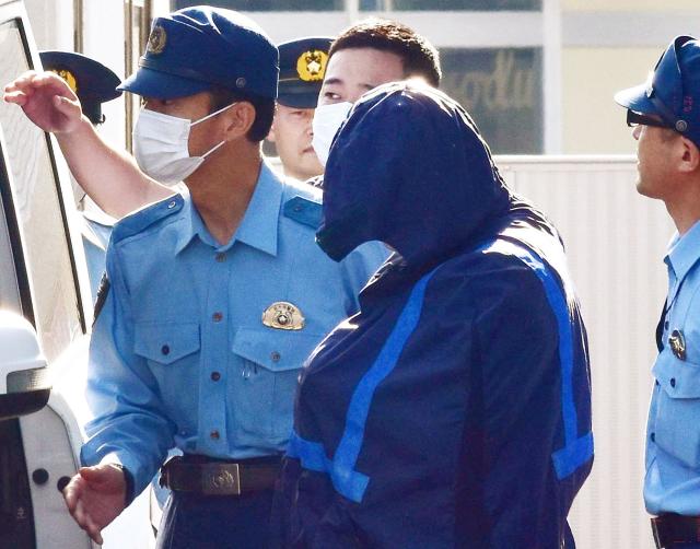 Kaito Takemae (C), the suspected ringleader in a robbery-murder case where four teenaged suspects broke into a home in Kaminokawa and stabbed a 69-year-old woman to death while also injuring her two children, is transferred from the Sakura Police Station to the public prosecutor's office in Sakura City, Tochigi Prefecture on May 18, 2026. (Photo by JIJI Press / AFP) / Japan OUT