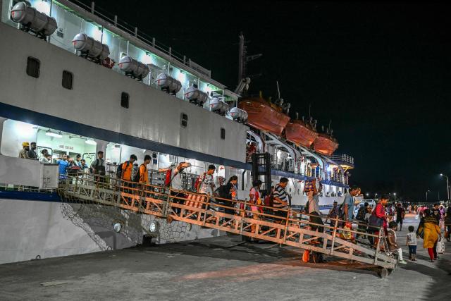 This photograph taken on March 30, 2026 shows passengers disembarking from the MV Kalighat vessel at Mus Jetty in India's Andaman and Nicobar Islands. Running from the archipelago's capital Sri Vijayapuram in the north to the southern tip of Campbell Bay, the ferry serves as both a passenger and cargo ship. (Photo by R. Satish BABU / AFP) / To go with 'India-Andaman Nicobar-Economy-Shipping-Tourism' by Bhuvan BAGGA