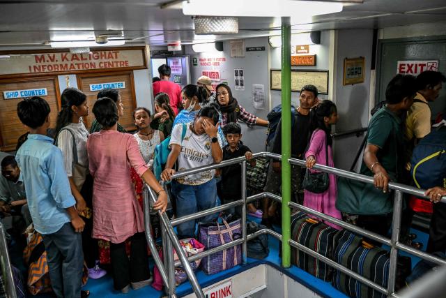 This photograph taken on March 30, 2026 shows passengers waiting to disembark from the MV Kalighat vessel at Mus Jetty in India's Andaman and Nicobar Islands. Running from the archipelago's capital Sri Vijayapuram in the north to the southern tip of Campbell Bay, the ferry serves as both a passenger and cargo ship. (Photo by R. Satish BABU / AFP) / To go with 'India-Andaman Nicobar-Economy-Shipping-Tourism' by Bhuvan BAGGA