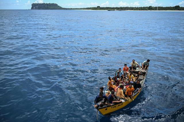 This photograph taken on March 30, 2026 shows passengers arriving on a boat to board the MV Kalighat vessel near Chowra in the waters of India's Andaman and Nicobar Islands. Running from the archipelago's capital Sri Vijayapuram in the north to the southern tip of Campbell Bay, the ferry serves as both a passenger and cargo ship. (Photo by R. Satish BABU / AFP) / To go with 'India-Andaman Nicobar-Economy-Shipping-Tourism' by Bhuvan BAGGA