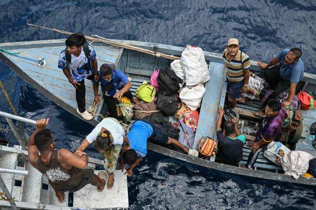 This photograph taken on March 30, 2026 shows passengers boarding the MV Kalighat vessel near Chowra in the waters of India's Andaman and Nicobar Islands. Running from the archipelago's capital Sri Vijayapuram in the north to the southern tip of Campbell Bay, the ferry serves as both a passenger and cargo ship. (Photo by R. Satish BABU / AFP) / To go with 'India-Andaman Nicobar-Economy-Shipping-Tourism' by Bhuvan BAGGA