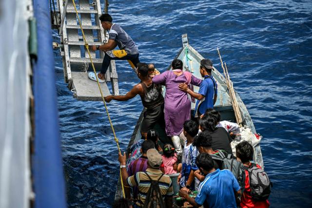 This photograph taken on March 30, 2026 shows passengers boarding the MV Kalighat vessel near Chowra in the waters of India's Andaman and Nicobar Islands. Running from the archipelago's capital Sri Vijayapuram in the north to the southern tip of Campbell Bay, the ferry serves as both a passenger and cargo ship. (Photo by R. Satish BABU / AFP) / To go with 'India-Andaman Nicobar-Economy-Shipping-Tourism' by Bhuvan BAGGA