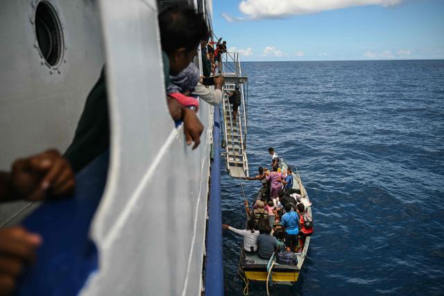 This photograph taken on March 30, 2026 shows passengers boarding the MV Kalighat vessel near Chowra in the waters of India's Andaman and Nicobar Islands. Running from the archipelago's capital Sri Vijayapuram in the north to the southern tip of Campbell Bay, the ferry serves as both a passenger and cargo ship. (Photo by R. Satish BABU / AFP) / To go with 'India-Andaman Nicobar-Economy-Shipping-Tourism' by Bhuvan BAGGA