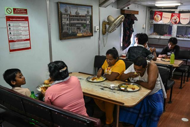 This photograph taken on March 30, 2026 shows passengers eating lunch on the MV Kalighat vessel plying across the waters of India's Andaman and Nicobar Islands. Running from the archipelago's capital Sri Vijayapuram in the north to the southern tip of Campbell Bay, the ferry serves as both a passenger and cargo ship. (Photo by R. Satish BABU / AFP) / To go with 'India-Andaman Nicobar-Economy-Shipping-Tourism' by Bhuvan BAGGA