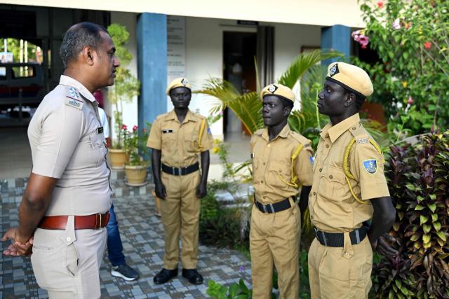 This photograph taken on March 22, 2026 shows Hut Bay police station inspector, Pritam Behari speaking with the members of the Onge tribal community who joined as police homeguards on Little Andaman island in India's Andaman and Nicobar Islands. Outsiders call the Indian Ocean island Little Andaman and its long-isolated guardians the Onge, but those preserving an age-old way of life now under threat have their own names. A $9 billion development plan across India's wider Andaman and Nicobar Islands will affect communities throughout the scattered archipelago. Authorities, treading a delicate line in managing contact, began last year recruiting more than 500 young men from communities across the archipelago as police "homeguards" to help manage relations with outsiders. (Photo by R. Satish BABU / AFP)