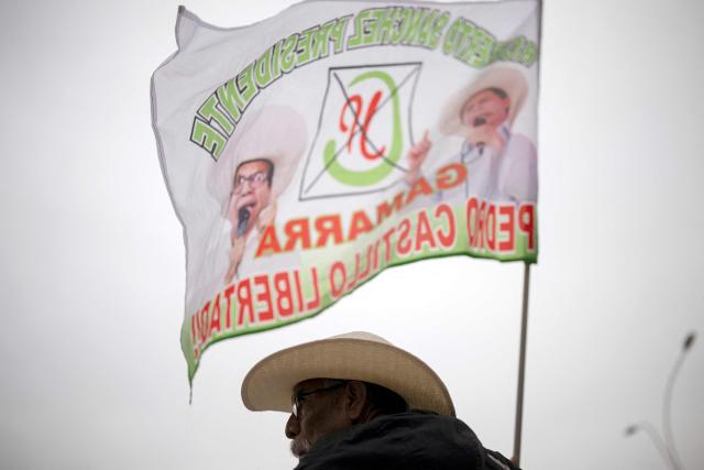A supporter of Peru's presidential candidate Roberto Sanchez, of the Juntos por el Peru party, holds a flag during a campaign rally in Lima on May 17, 2026. Left-wing candidate Roberto Sanchez has qualified for the runoff of Peru's presidential election and will face right-wing candidate Keiko Fujimori in June 7. (Photo by Ernesto BENAVIDES / AFP)