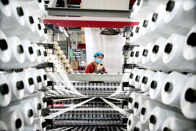 A worker monitors products for export at a packaging factory in Lianyungang, in China's eastern Jiangsu Province, on May 18, 2026. (Photo by CN-STR / AFP) / China OUT