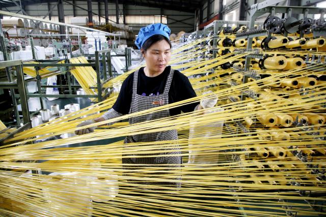 A worker monitors products for export at a packaging factory in Lianyungang, in China's eastern Jiangsu Province, on May 18, 2026. (Photo by CN-STR / AFP) / China OUT