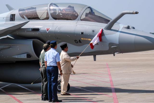 Indonesian President Prabowo Subianto (C) unveils a Rafale jet fighter during a ceremony to hand over six new Rafale jet fighters, six Dassault Falcon 8X aircrafts and two Airbus A400M Atlas transport planes to the Indonesian Air Force at Halim Perdanakusuma Air Force Base in Jakarta on May 18, 2026. (Photo by BAY ISMOYO / AFP)