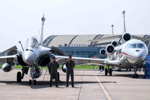Fighter pilots stand near aircrafts during a ceremony to hand over six new Rafale jet fighters, six Dassault Falcon 8X aircrafts and two Airbus A400M Atlas transport planes to the Indonesian Air Force at Halim Perdanakusuma Air Force Base in Jakarta on May 18, 2026. (Photo by BAY ISMOYO / AFP)