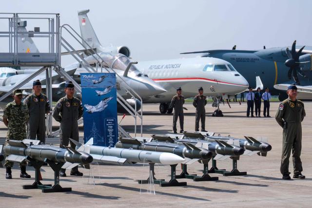 Fighter pilots stand near aircrafts during a ceremony to hand over six new Rafale jet fighters, six Dassault Falcon 8X aircrafts and two Airbus A400M Atlas transport planes to the Indonesian Air Force at Halim Perdanakusuma Air Force Base in Jakarta on May 18, 2026. (Photo by BAY ISMOYO / AFP)