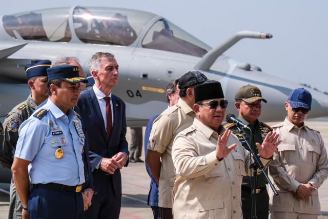 Indonesian President Prabowo Subianto (front) delivers a statement to journalists during a ceremony to hand over six new Rafale jet fighters, six Dassault Falcon 8X aircrafts and two Airbus A400M Atlas transport planes to the Indonesian Air Force at Halim Perdanakusuma Air Force Base in Jakarta on May 18, 2026. (Photo by BAY ISMOYO / AFP)