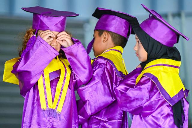 Kindergarteners in gowns look on as they wait to have their graduation photographs taken at the Aceh Tsunami Museum on International Museum Day in Banda Aceh on May 18, 2026. (Photo by CHAIDEER MAHYUDDIN / AFP)