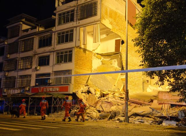 Rescuers walk past a collapsed building after an earthquake in Liuzhou, China's southern Guangxi region on May 18, 2026. A 5.2-magnitude earthquake struck south China's Guangxi region on May 18, killing two people and causing 13 buildings to collapse, state media reported. (Photo by CNS / AFP) / China OUT