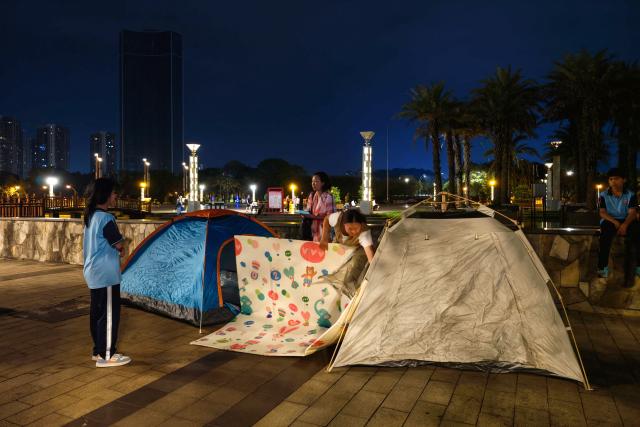People prepare tents for shelter at a square after an earthquake at Liunan district in Liuzhou, China's southern Guangxi region on May 18, 2026. A 5.2-magnitude earthquake struck south China's Guangxi region on May 18, killing two people and causing 13 buildings to collapse, state media reported. (Photo by CNS / AFP) / China OUT