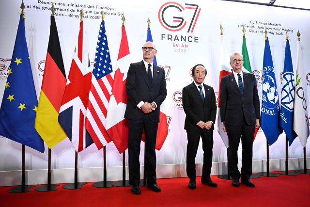 France's Economy, Finances and Industry Minister Roland Lescure (L) and Governor of the Bank of France François Villeroy de Galhau (R) greet Governor of the Bank of Japan Kazuo Ueda prior to a meeting of G7 Finance Ministers and Central Bank Governors in preparation for the summit of heads of State and government to be held in June 2026 in Evian, in Paris on May 18, 2026. (Photo by JULIEN DE ROSA / AFP)