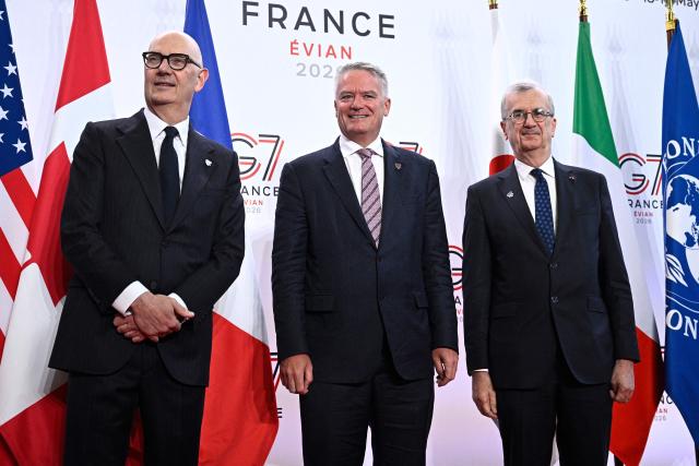 France's Economy, Finances and Industry Minister Roland Lescure (L) and Governor of the Bank of France François Villeroy de Galhau (R) greet Secretary-General of the Organisation for Economic Co-operation and Development (OECD) Mathias Cormann prior to a meeting of G7 Finance Ministers and Central Bank Governors in preparation for the summit of heads of State and government to be held in June 2026 in Evian, in Paris on May 18, 2026. (Photo by JULIEN DE ROSA / AFP)