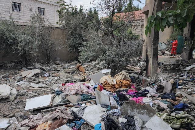 TOPSHOT - An emergency worker inspects the damage following an Israeli strike on an apartment building in Baalbek on May 18, 2026. An Israeli missile strike on an apartment in eastern Lebanon on May 17 killed an Islamic Jihad commander and his 17-year-old daughter, Lebanese state media said. (Photo by AFP)