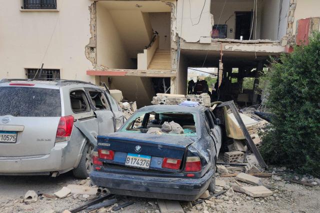 TOPSHOT - Emergency workers inspect the damage following an Israeli strike on an apartment building in Baalbek on May 18, 2026. An Israeli missile strike on an apartment in eastern Lebanon on May 17 killed an Islamic Jihad commander and his 17-year-old daughter, Lebanese state media said. (Photo by AFP)