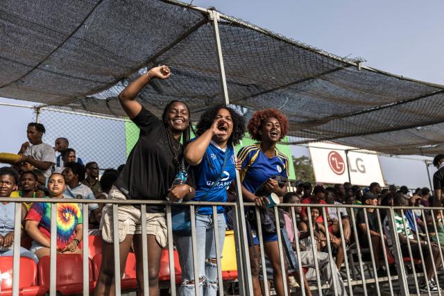 Desportivo da Praia supporters celebrate after their team scored a goal during the Praia Cup final football match between Desportivo da Praia and Sporting Clube da Praia at the Estadio da Varzea in Praia, on April 4, 2026. Both teams played the final for a chance to qualify for the Cape Verdean Cup, a knockout tournament that brings together the champions of each island. 
This archipelago of 10 islands is the smallest African nation ever to qualify for a World Cup with a population of just 550,000. 
The national team, known as the Blue Sharks, will compete in Group H against Spain, Saudi Arabia, and Uruguay. 
Their World Cup qualification has inspired many players in the local leagues, who now dream of joining the national team and representing their country. (Photo by PATRICK MEINHARDT / AFP)