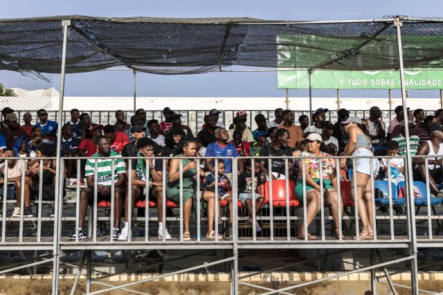Supporters watch during the Praia Cup final football match between Desportivo da Praia and Sporting Clube da Praia at the Estadio da Varzea in Praia, on April 4, 2026. Both teams played the final for a chance to qualify for the Cape Verdean Cup, a knockout tournament that brings together the champions of each island. 
This archipelago of 10 islands is the smallest African nation ever to qualify for a World Cup with a population of just 550,000. 
The national team, known as the Blue Sharks, will compete in Group H against Spain, Saudi Arabia, and Uruguay. 
Their World Cup qualification has inspired many players in the local leagues, who now dream of joining the national team and representing their country. (Photo by PATRICK MEINHARDT / AFP)