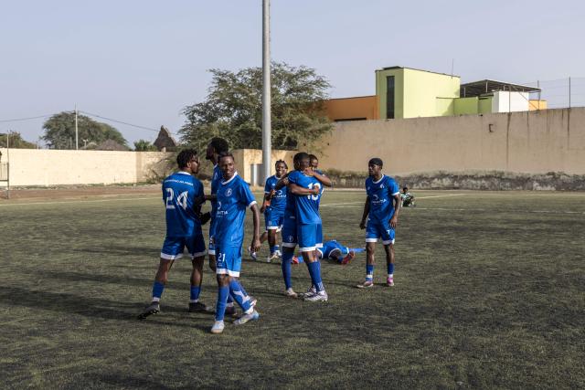 Desportivo da Praia players celebrate after winning the Praia Cup final football match between Desportivo da Praia and Sporting Clube da Praia at the Estadio da Varzea in Praia, on April 4, 2026. Both teams played the final for a chance to qualify for the Cape Verdean Cup, a knockout tournament that brings together the champions of each island. 
This archipelago of 10 islands is the smallest African nation ever to qualify for a World Cup with a population of just 550,000. 
The national team, known as the Blue Sharks, will compete in Group H against Spain, Saudi Arabia, and Uruguay. 
Their World Cup qualification has inspired many players in the local leagues, who now dream of joining the national team and representing their country. (Photo by PATRICK MEINHARDT / AFP)