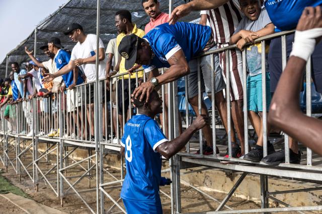 Desportivo da Praia supporters celebrate with players after winning the Praia Cup final football match between Desportivo da Praia and Sporting Clube da Praia at the Estadio da Varzea in Praia, on April 4, 2026. Both teams played the final for a chance to qualify for the Cape Verdean Cup, a knockout tournament that brings together the champions of each island. 
This archipelago of 10 islands is the smallest African nation ever to qualify for a World Cup with a population of just 550,000. 
The national team, known as the Blue Sharks, will compete in Group H against Spain, Saudi Arabia, and Uruguay. 
Their World Cup qualification has inspired many players in the local leagues, who now dream of joining the national team and representing their country. (Photo by PATRICK MEINHARDT / AFP)