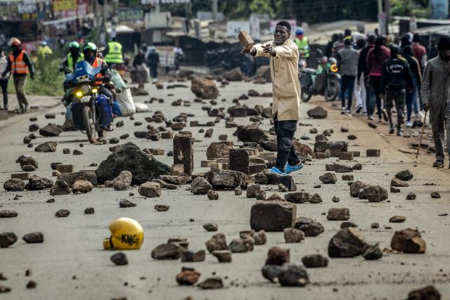 A protester blocks a road with stones to prevent traffic from passing during a nationwide transport strike over rising fuel prices in Nairobi on May 18, 2026. Public transport was largely shut down and protesters barricaded roads in Kenya on May 18, 2026 as a strike was called over a fuel price hike triggered by the Middle East war.
Kenya is one of many African countries dependent on fuel imports from the Gulf, and heavily hit by Iran's effective closure of the Strait of Hormuz through which a fifth of the world's oil normally passes. (Photo by Luis TATO / AFP)