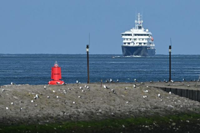 The Dutch Hantavirus-hit cruise ship MV Hondius sails off the Netherlands' coast as it approaches the port of Rotterdam on May 18, 2026. Cruise ship MV Hondius is expected to arrive at the port of Rotterdam and the ship's crew members will undergo a medical screening. (Photo by NICOLAS TUCAT / AFP)