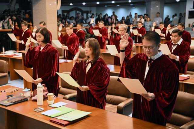 Philippine senators take their oath as jurors in the impeachment trial of Vice President Sara Duterte at the plenary hall of the Senate in Manila on May 18, 2026. (Photo by Ted ALJIBE / AFP)