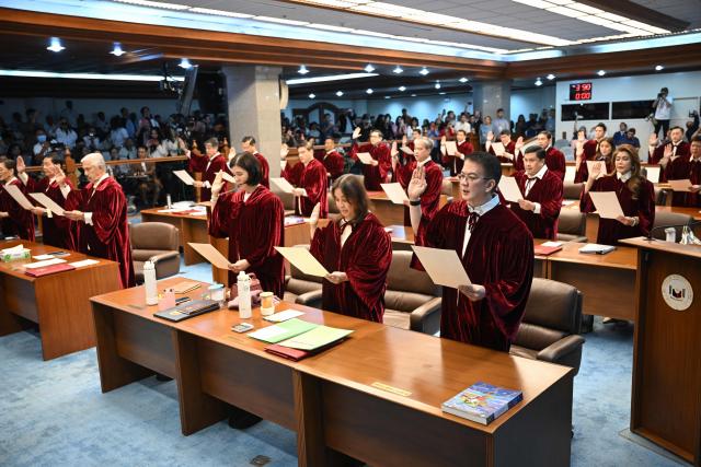 Philippine senators take their oath as jurors in the impeachment trial of Vice President Sara Duterte at the plenary hall of the Senate in Manila on May 18, 2026. (Photo by Ted ALJIBE / AFP)