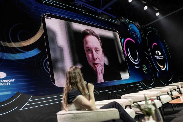 Tesla and SpaceX CEO Elon Musk is seen on a large screen during a long distance Q&A session at the Smart Mobility Summit 2026, in Tel Aviv on May 18, 2026. (Photo by ilia YEFIMOVICH / AFP)